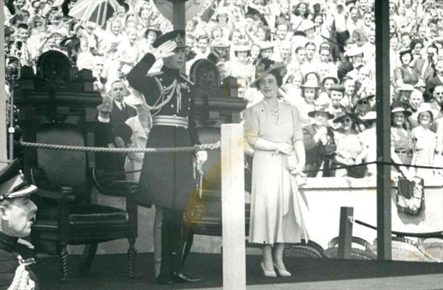 king and queen saluting with onlooking crowd