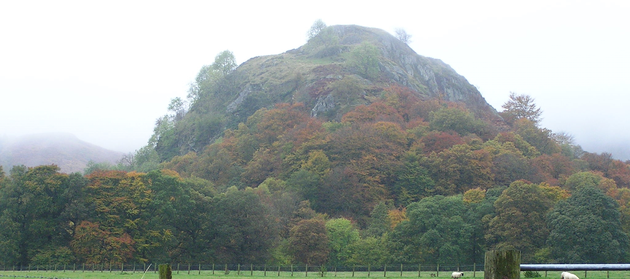 a rocky hill against an overcast sky