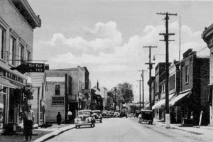 historic small town downtown streetscape ca. 1920 with old cars and buildings